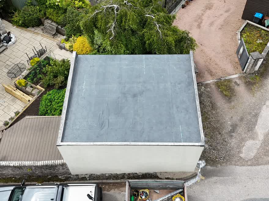 Aerial view of a completed EPDM rubber flat roof on a detached outbuilding