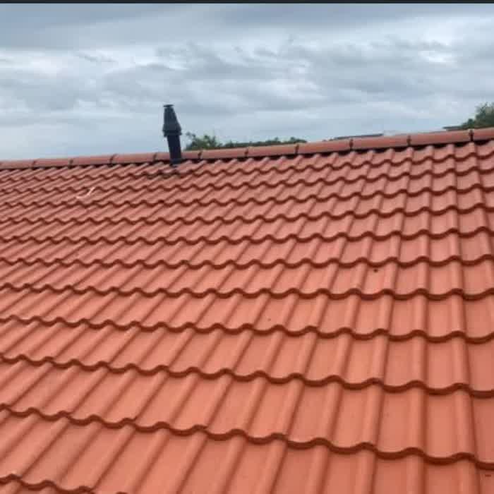 Close view of a freshly laid terracotta pantile roof and ridge