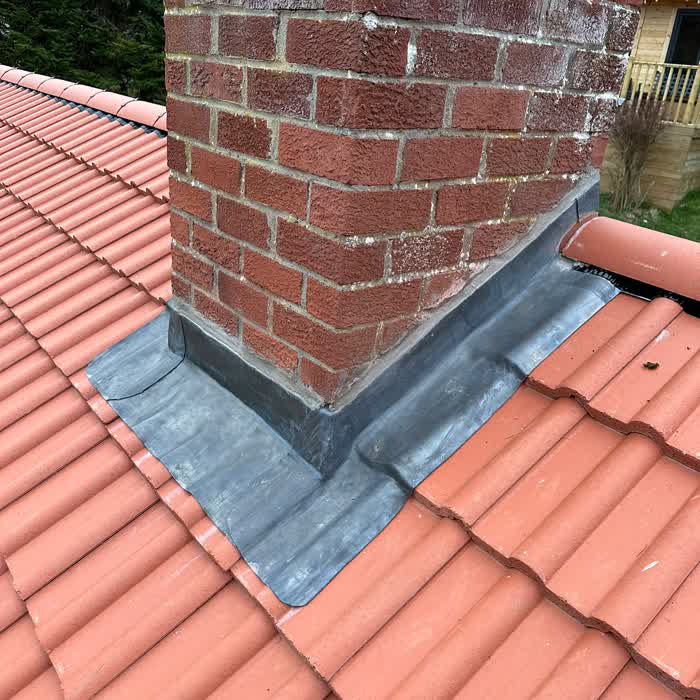 Lead step flashing and back gutter completed around a brick chimney
