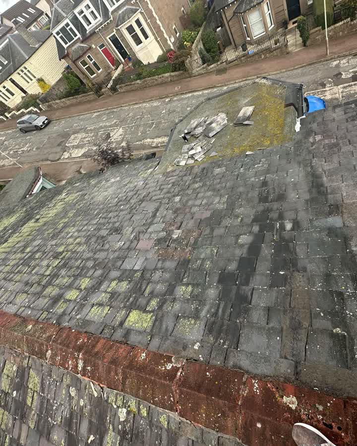 Old slate roof covered in moss and lichen with patched and mismatched slates before the re-roof